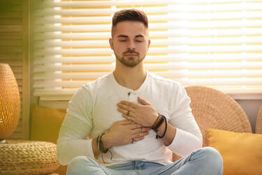 Man with hands on chest giving himself Reiki